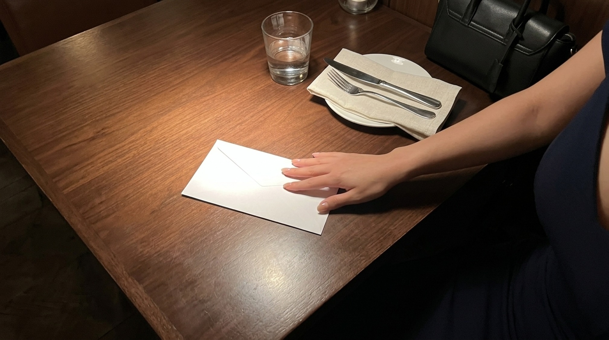 パパ活のお手当を白封筒でテーブルに置いて渡す場面